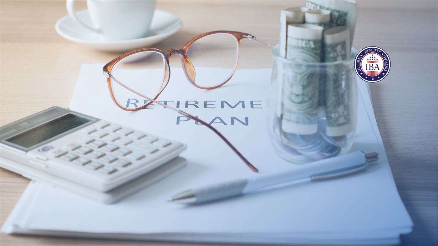 Reading glasses, a calculator, a pen and rolled banknotes resting on a printed retirement plan document