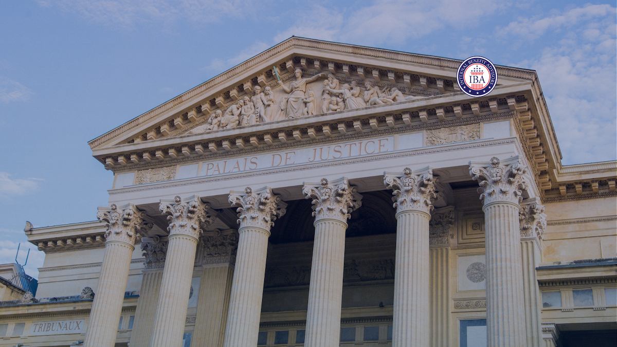 A neoclassical courthouse with tall columns and Palais de Justice carved above the entrance