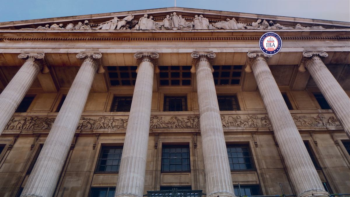 Looking up at the columns and sculpted pediment of a classical government building