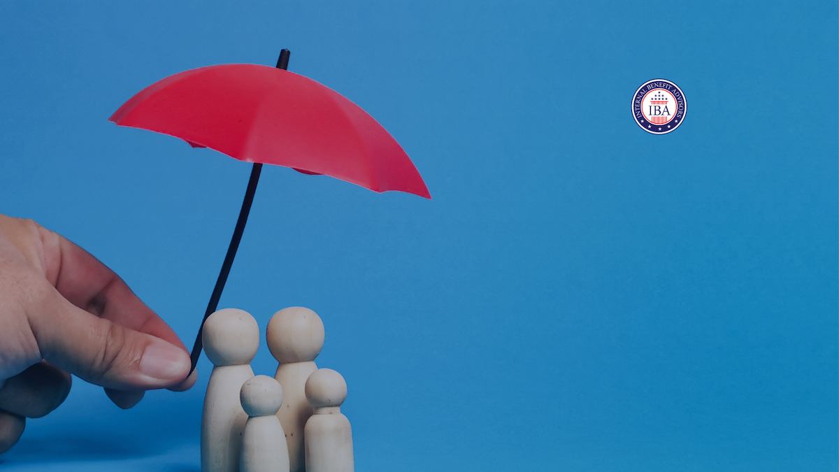 A hand holding a small red umbrella over four wooden figures representing a family, against a blue background