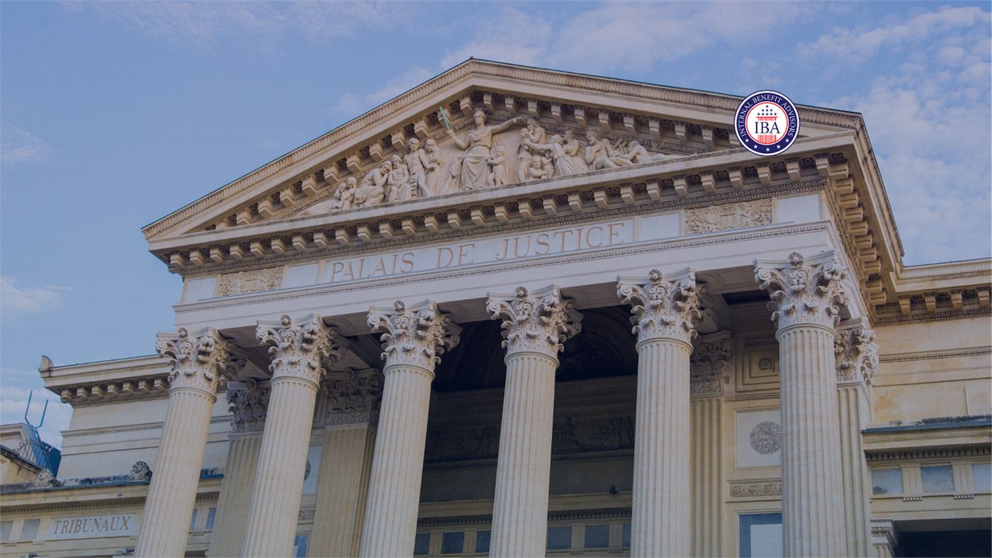 A neoclassical courthouse with columns and Palais de Justice carved above the entrance