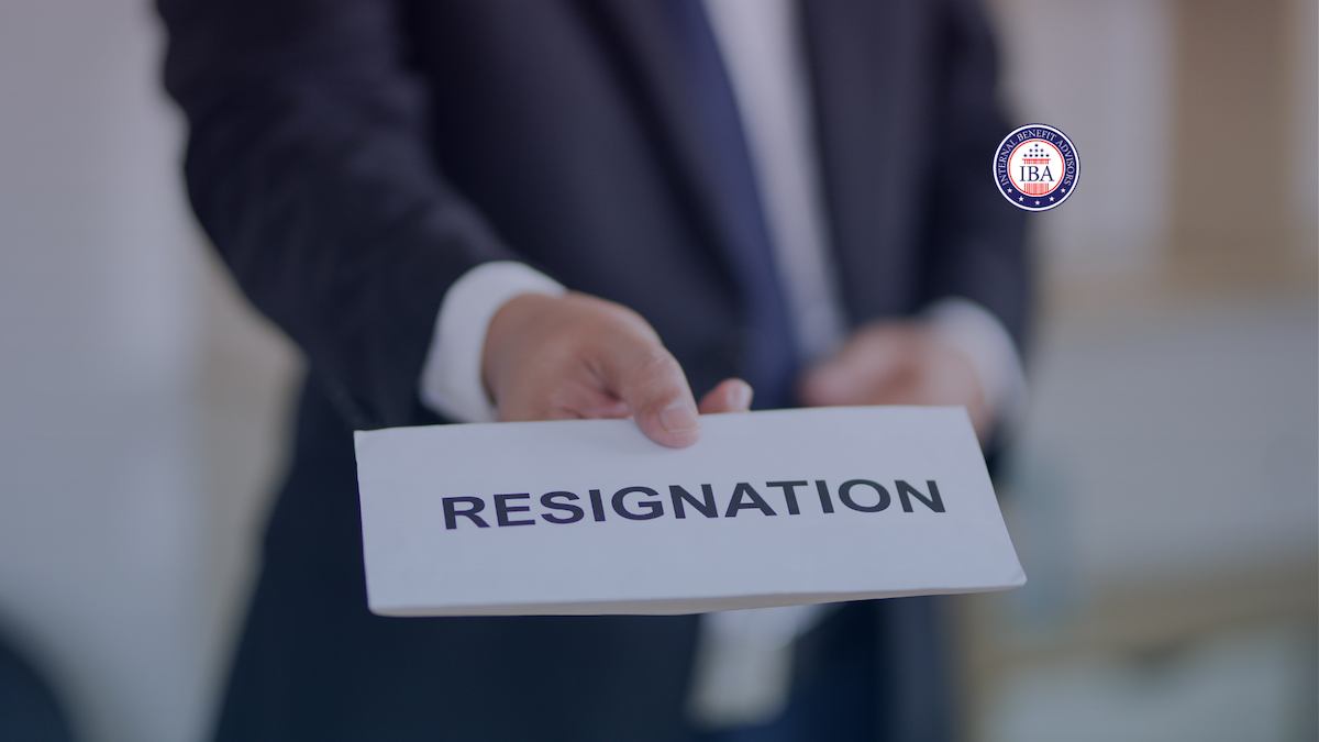 A man in a suit holding out a sealed envelope marked Resignation