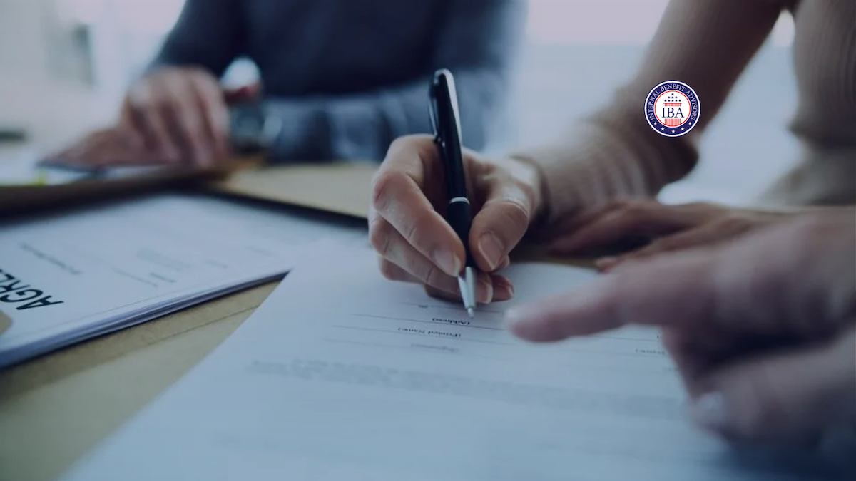 Close-up of a hand signing a document held on a clipboard