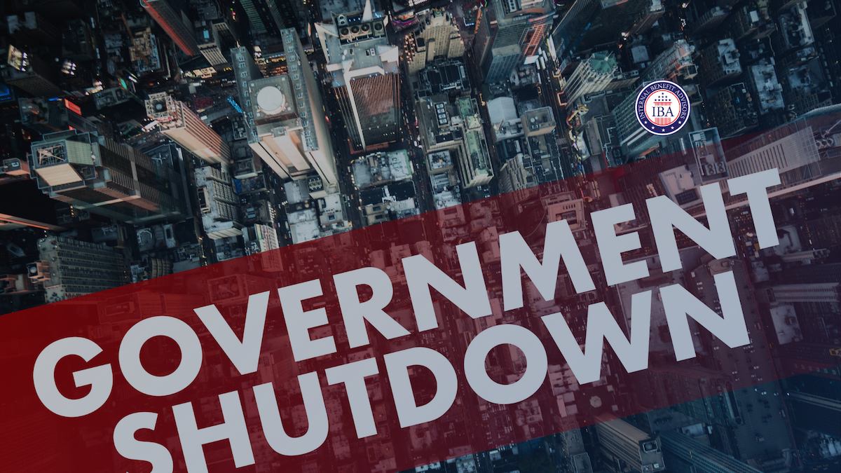 An aerial view of a city at night with the words Government Shutdown across a red banner