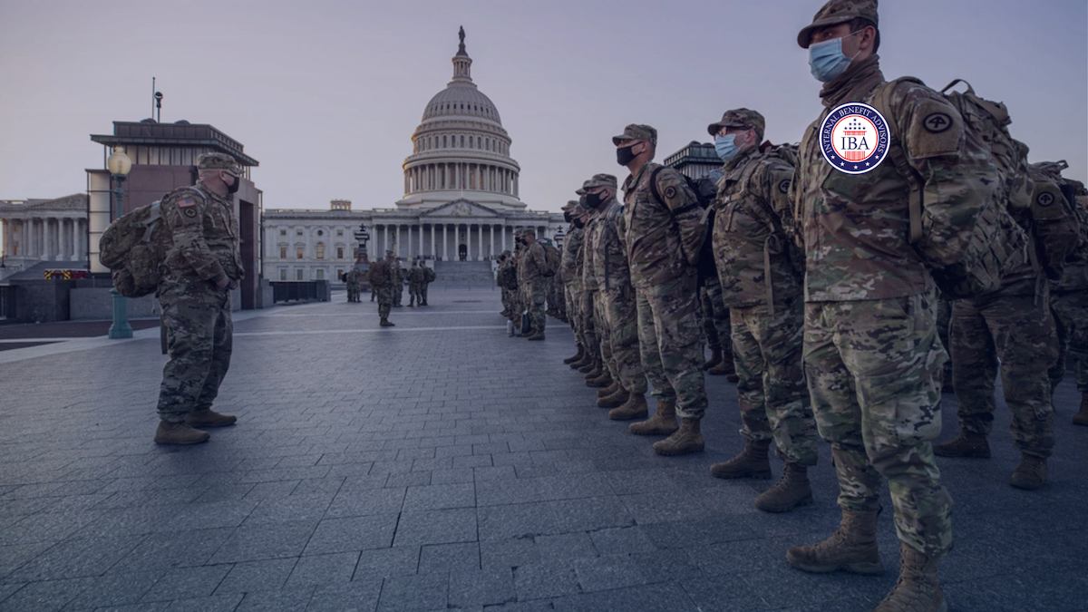 National Guard troops in camouflage standing in formation in front of the Capitol