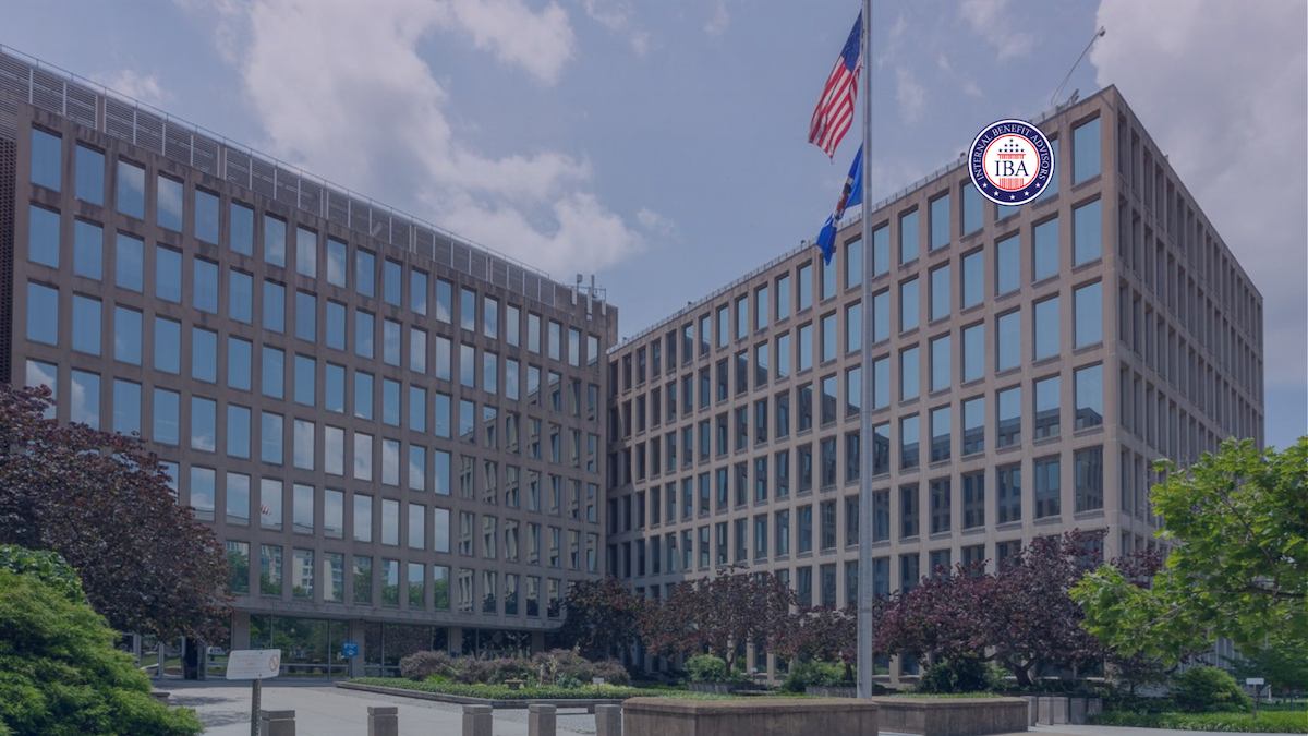 A large mid-century federal office building with flags flying outside