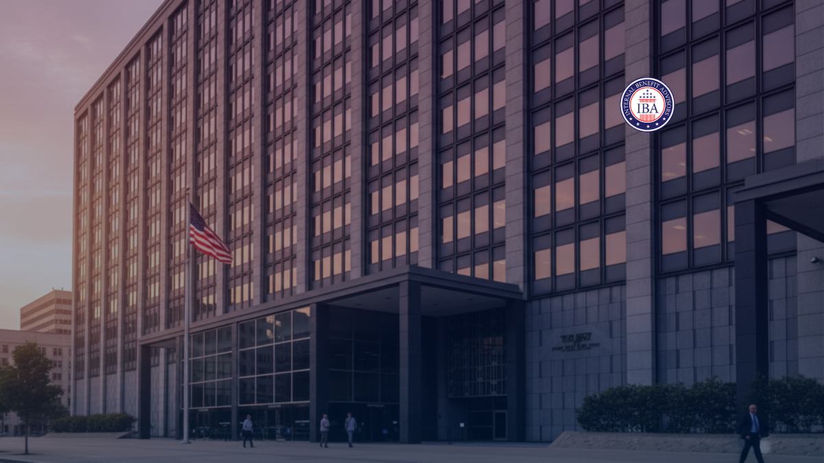 A large federal office building at dusk with an American flag outside