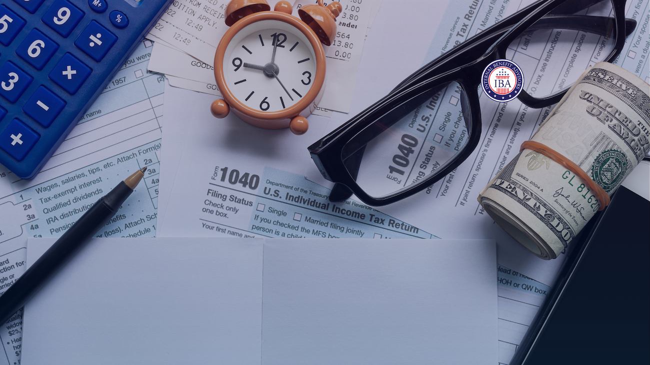 A calculator, alarm clock, reading glasses and rolled banknotes resting on a US 1040 income tax return