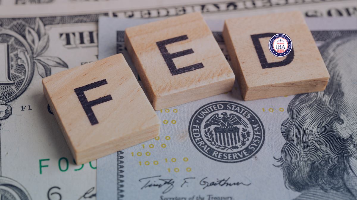 Wooden blocks spelling FED resting on US banknotes bearing the Federal Reserve System seal
