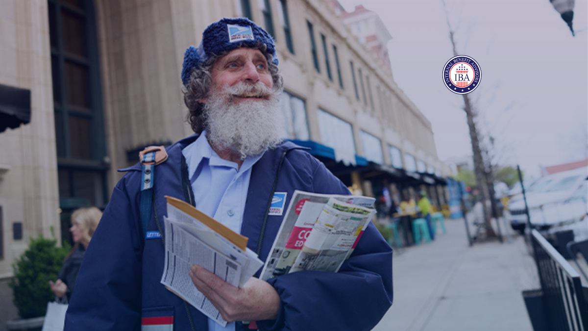 A bearded postal worker in uniform carrying mail along a city street
