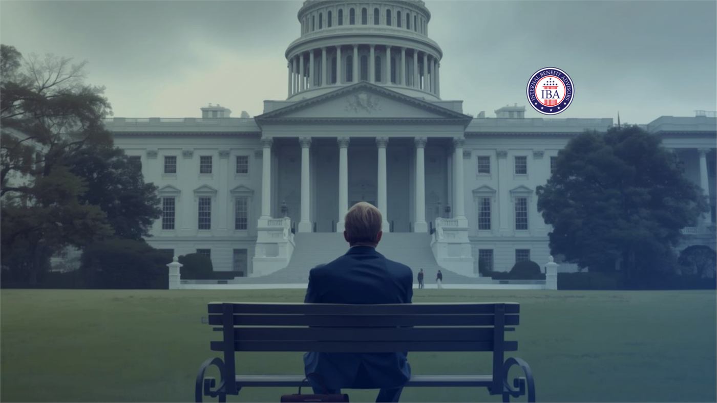 A man sitting alone on a bench looking toward the White House