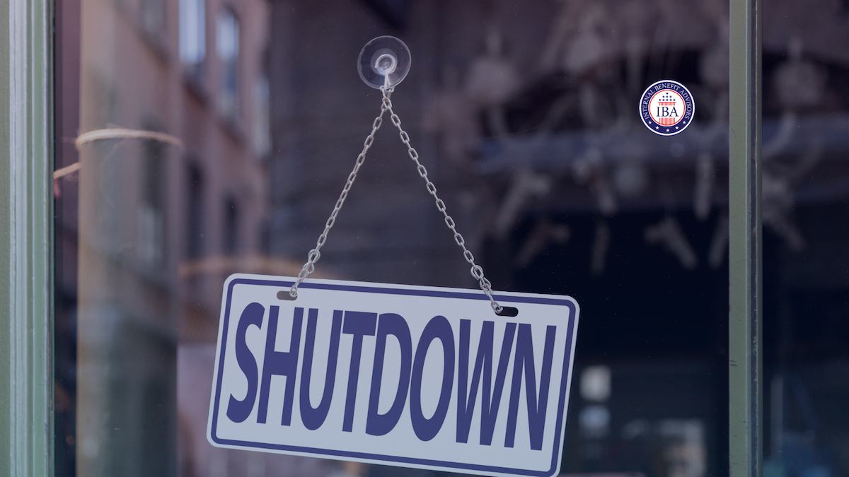 A shop window sign hanging on a chain reading Shutdown
