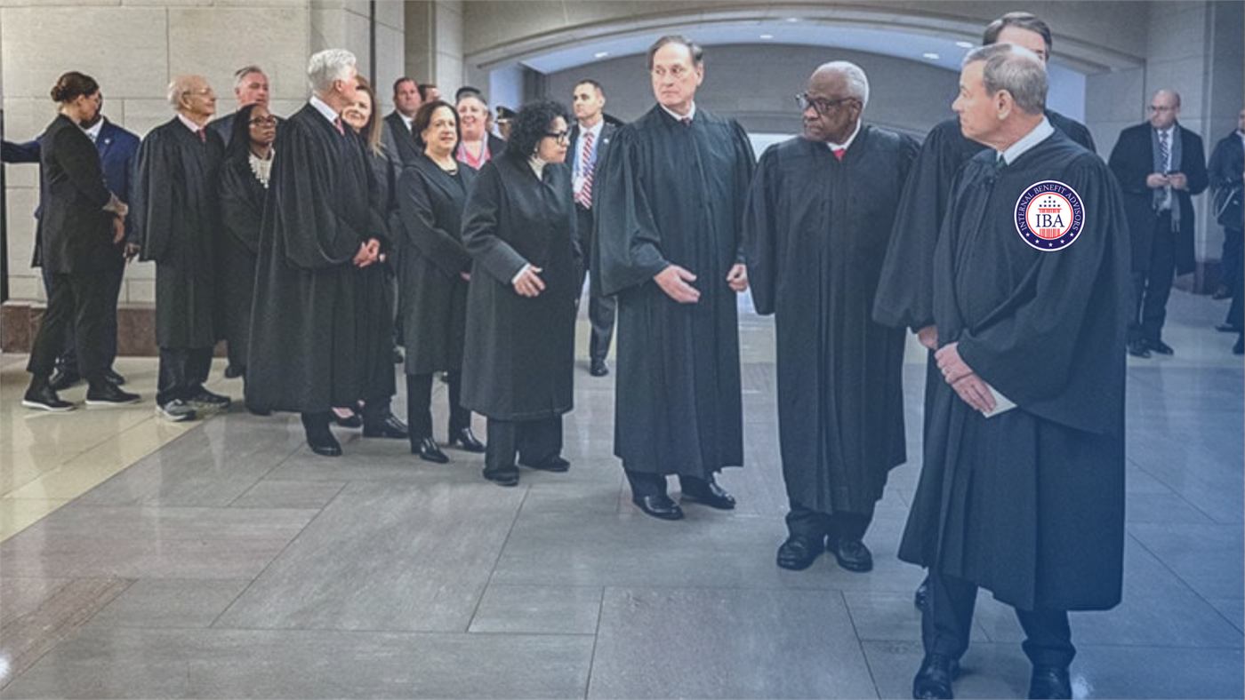 Supreme Court justices in robes standing together in a marble hall