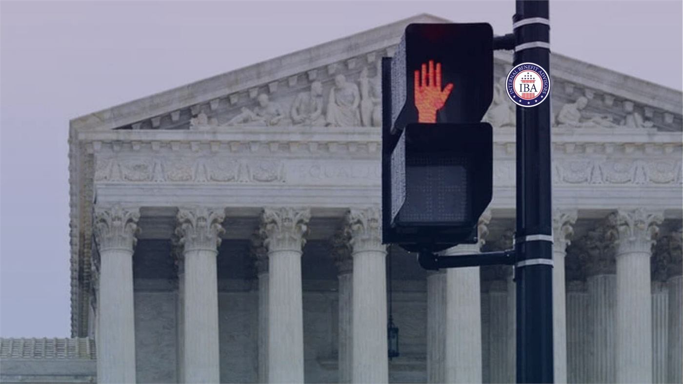 A pedestrian crossing signal showing a red hand in front of the Supreme Court