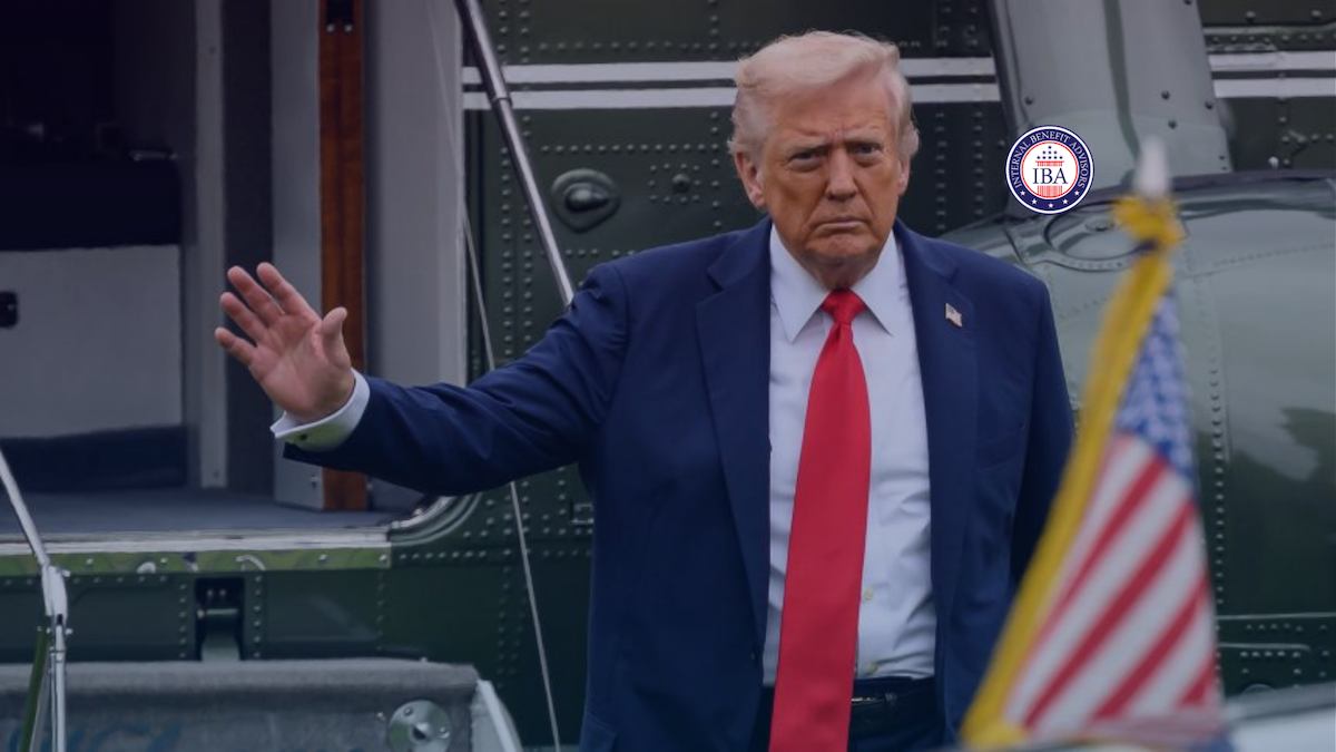 Donald Trump gesturing at the door of a helicopter beside an American flag