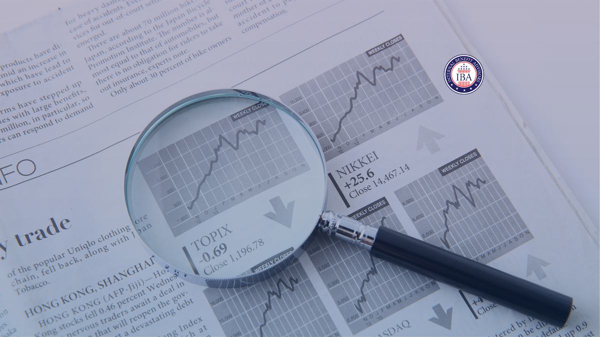 A magnifying glass held over stock market listings in a newspaper