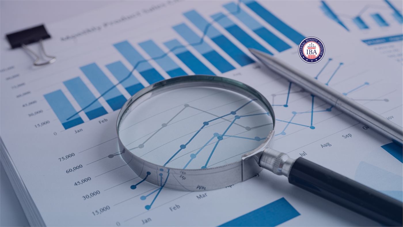 A magnifying glass resting on a printed bar chart and line graph