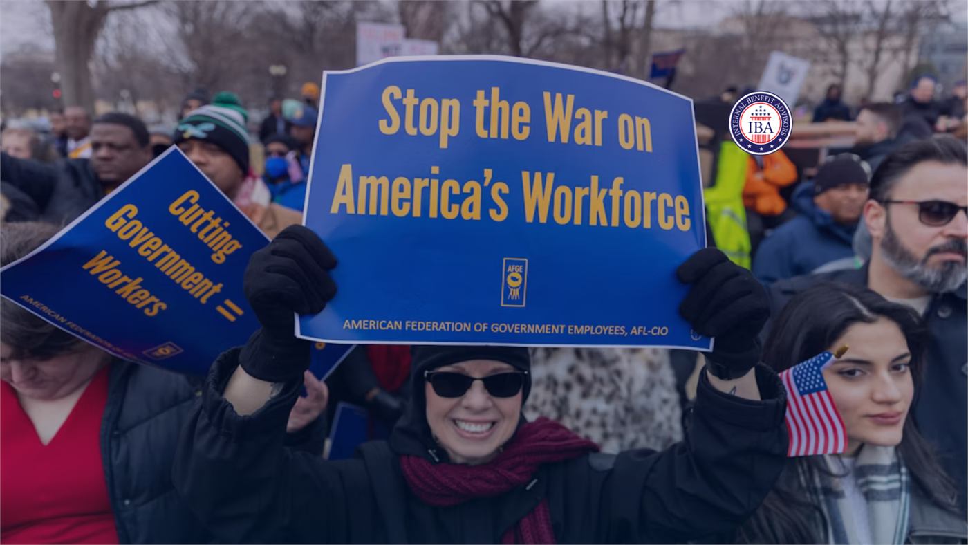 Demonstrators holding signs reading Stop the War on America's Workforce and Cutting Government Workers