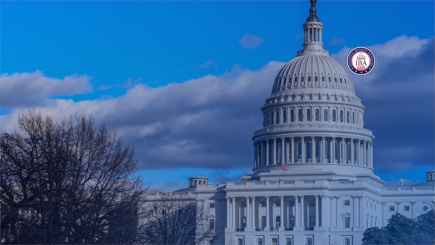 The Capitol dome against a blue sky framed by bare winter trees