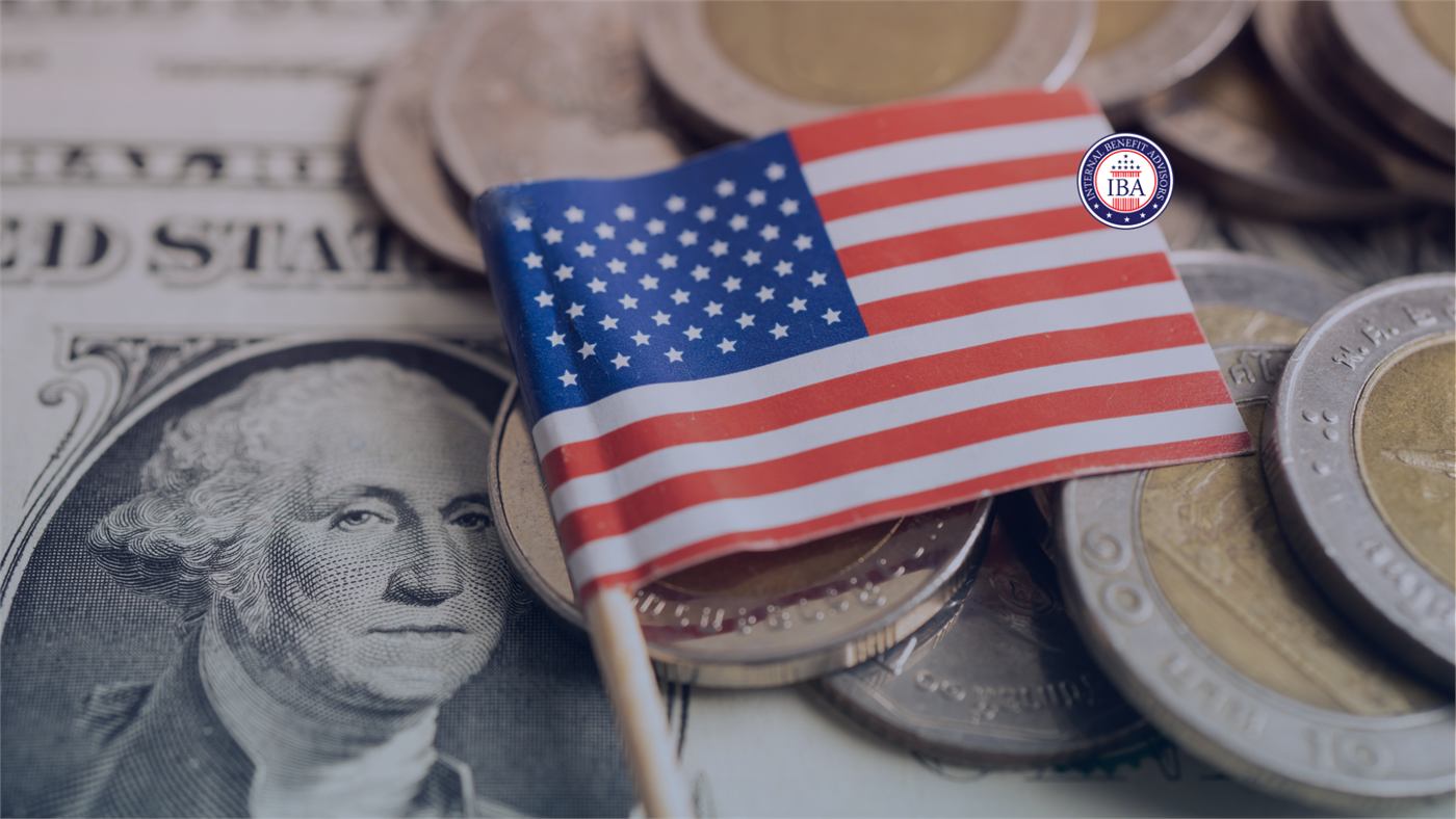 A small American flag standing among coins and a one dollar bill