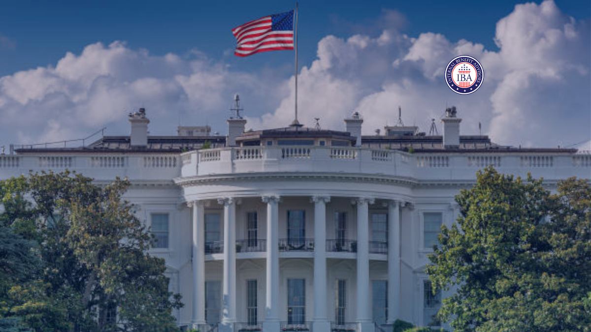 The White House beneath a blue sky, an American flag flying above it